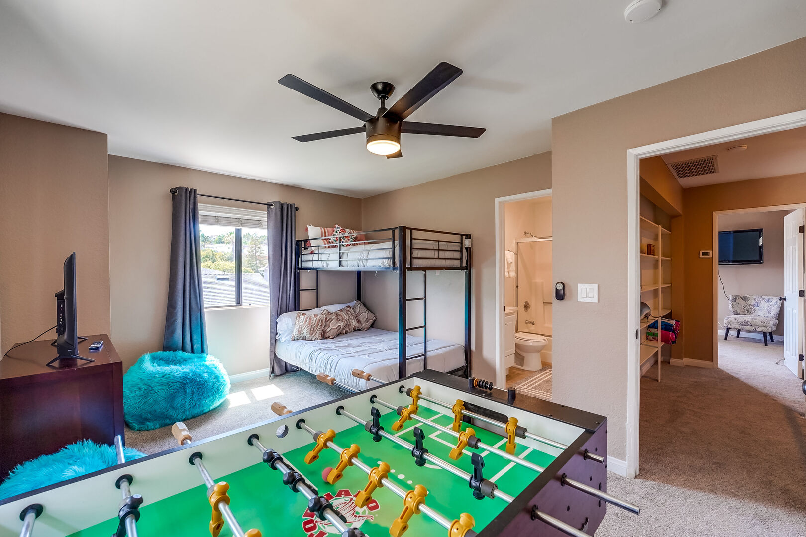 Upstairs guest room, perfect for kids! Full size bottom bunk and twin size top bunk beds. Remote control ceiling fan and light. Foosball table, hallway shelves full of board games, fuzzy bean bag chairs and smart TV. Closet and dresser storage with in-suite full bathroom.