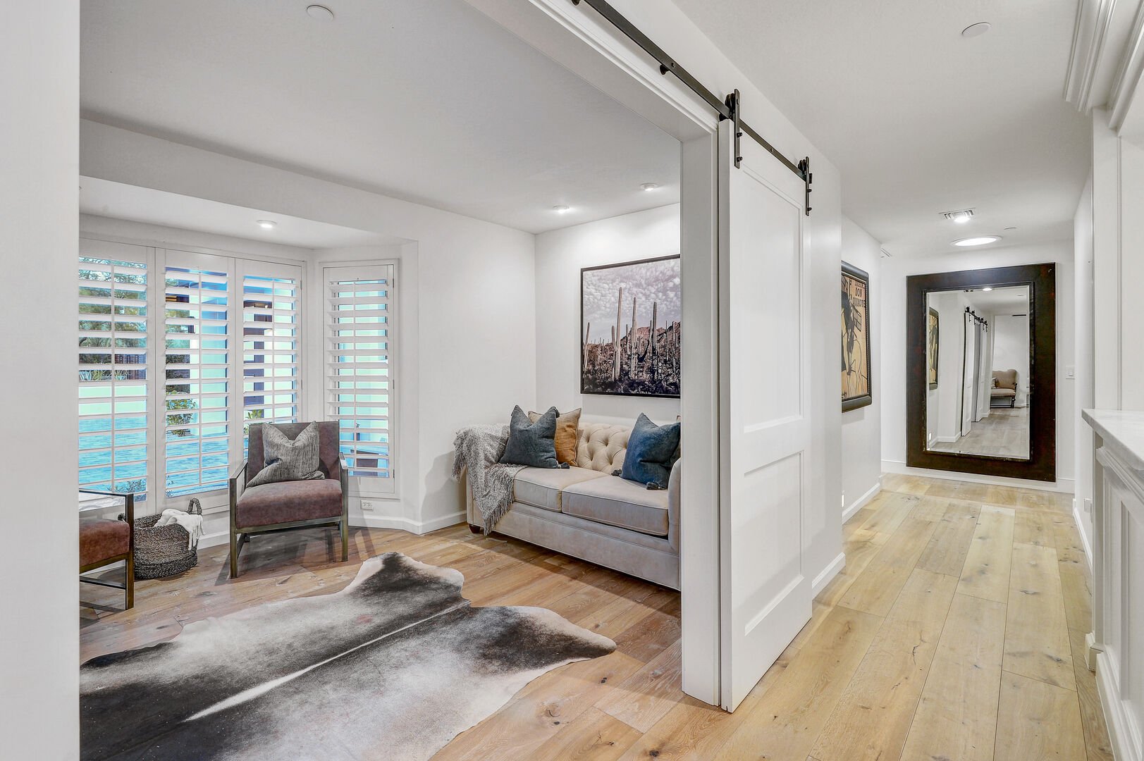 The inviting office space and the gracefully designed hallway, guiding the path to the enchanting east wing, luxurious master bedroom, and the allure of the upper floor.