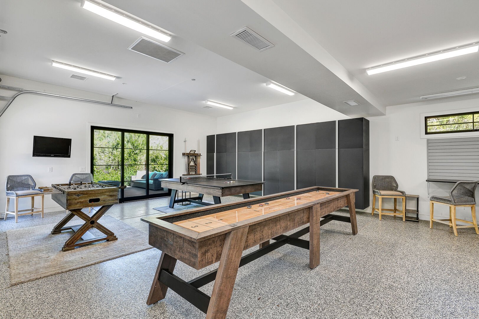 The garage, kept at a comfortable temperature, is also a game room with shuffleboard, a pool table that turns into ping pong, and foosball.