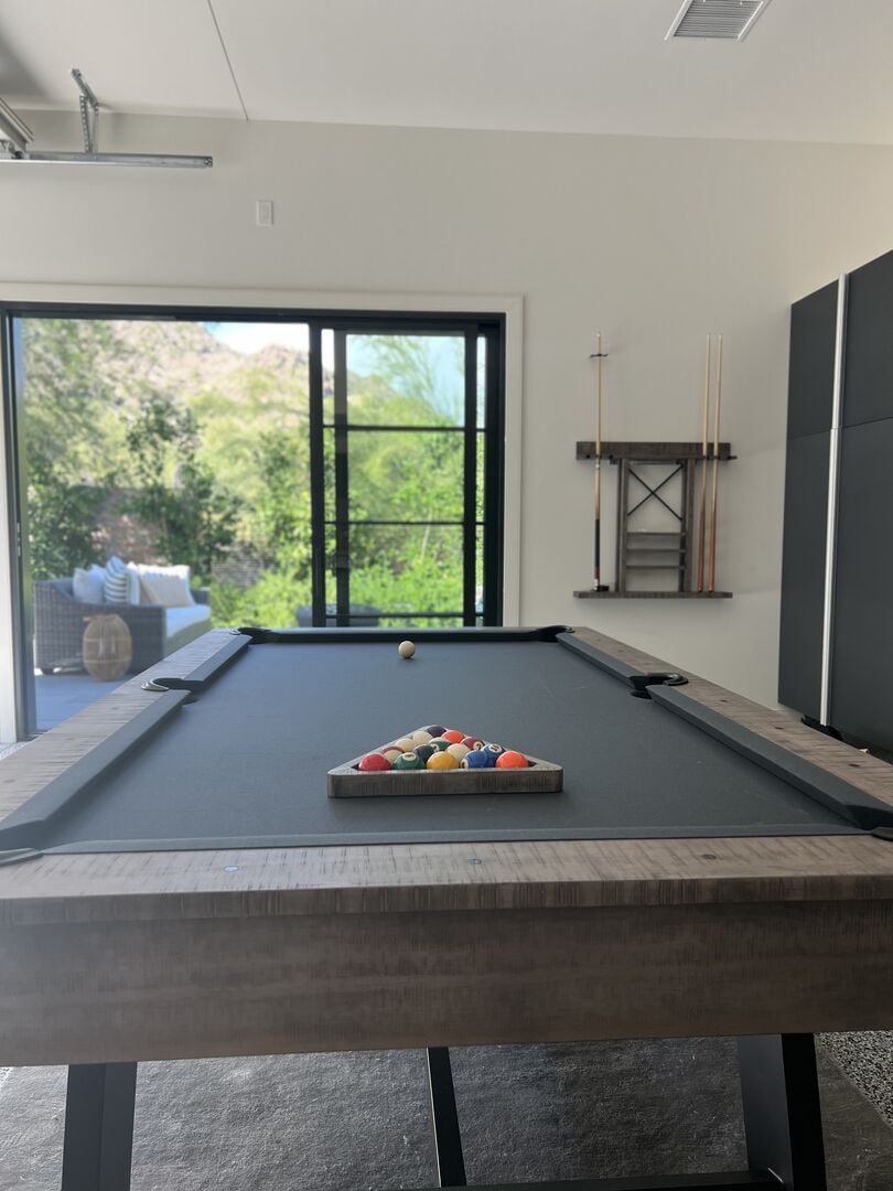 The game room boasts a stylish billiards table, providing a focal point for entertainment and leisure.