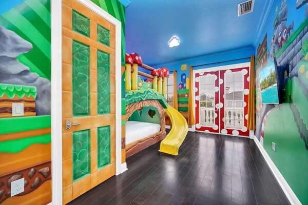 This themed room boasts a playful slide from the bed to the floor, adorned with a burst of vibrant colors.