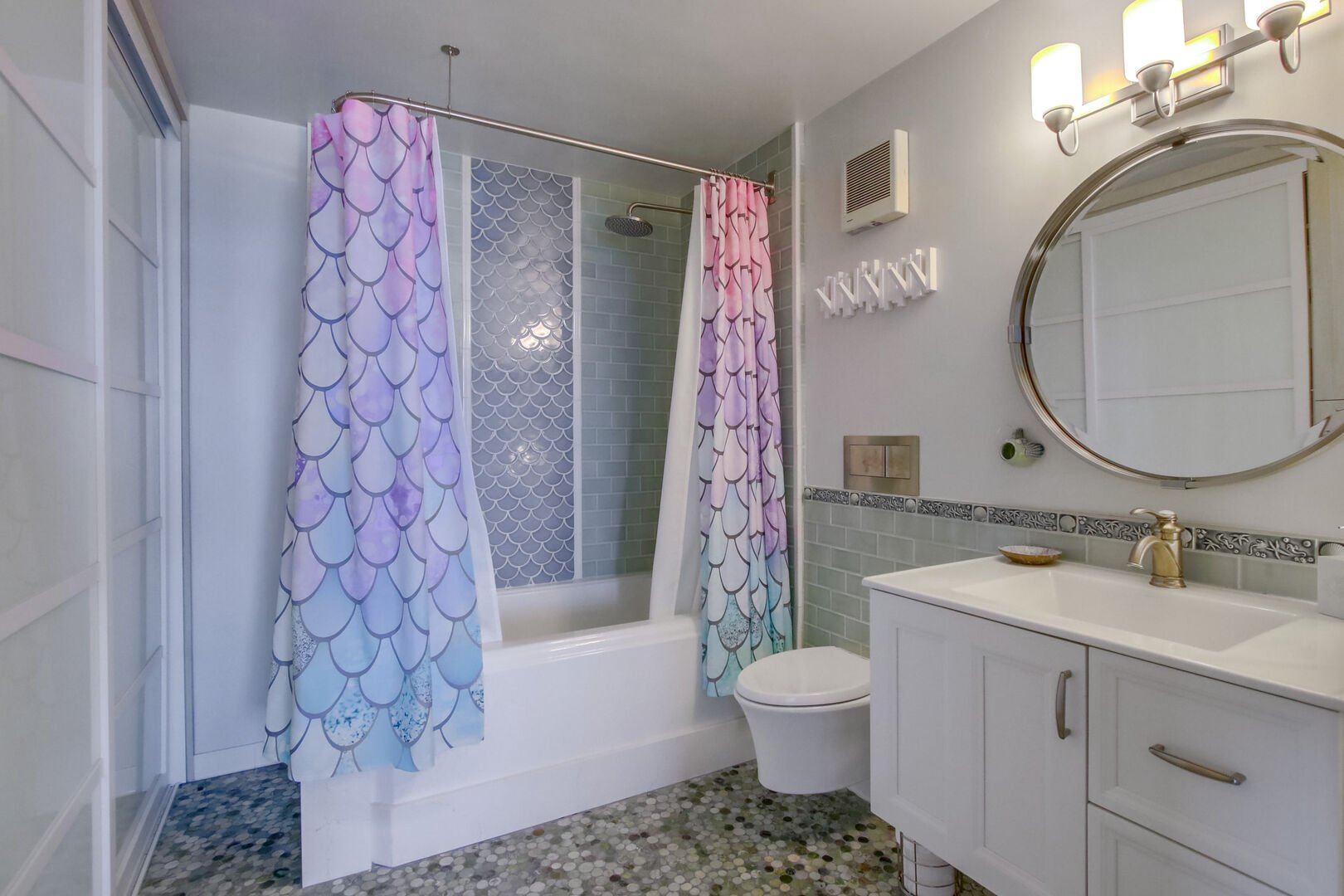 Master bathroom has a shower-tub combo with rainfall shower head, built-in closet and drawers, toilet and luxurious vanity