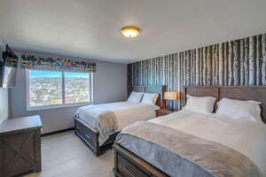 Guest bedroom with two queen size beds and north PB and La Jolla views from the window