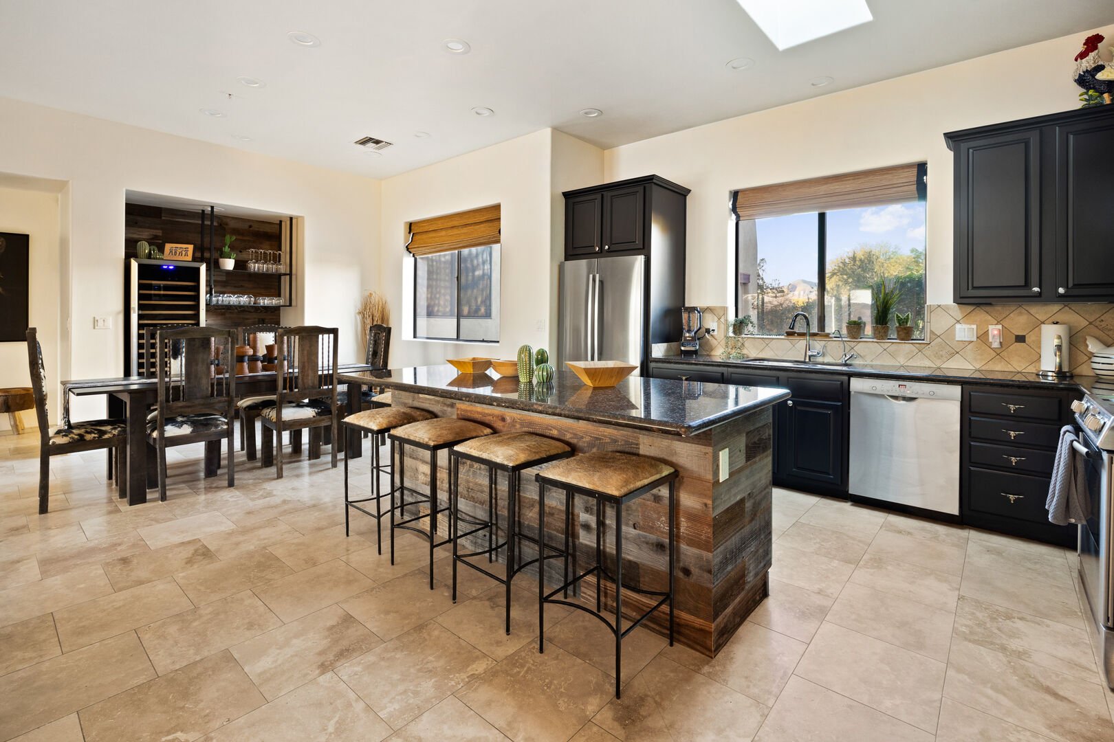 A 6 person dining table and 4 barstools at the kitchen island.