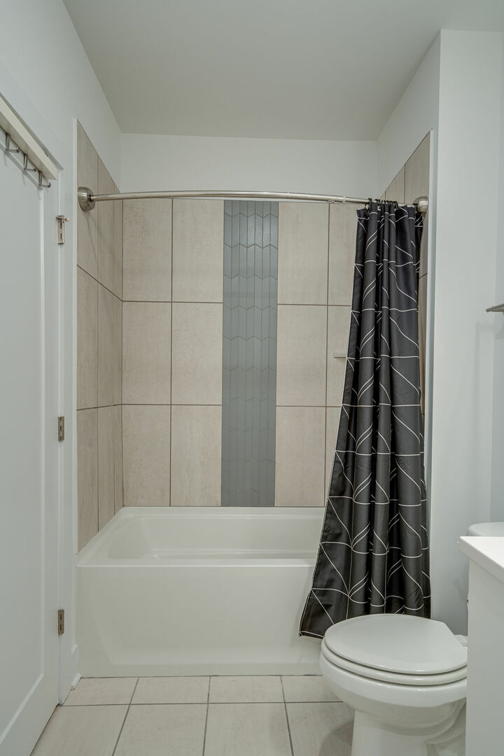 Bathroom with shower tub combo, walk in closet and washer and dryer