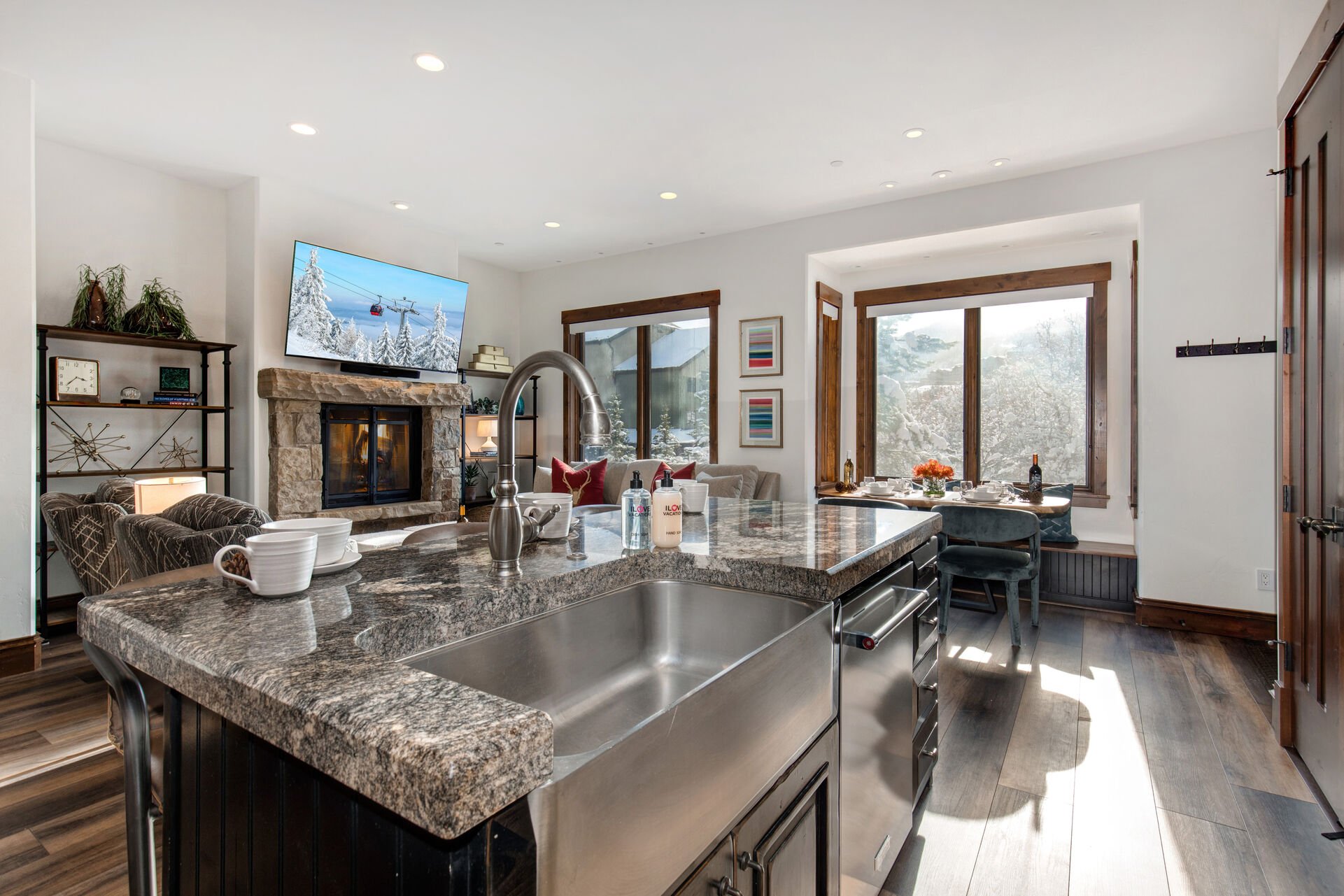 Fully equipped gourmet kitchen boasting high-end Viking appliances including a six-burner gas range and convection oven, stunning granite countertops, and a large center island with plush seating for three