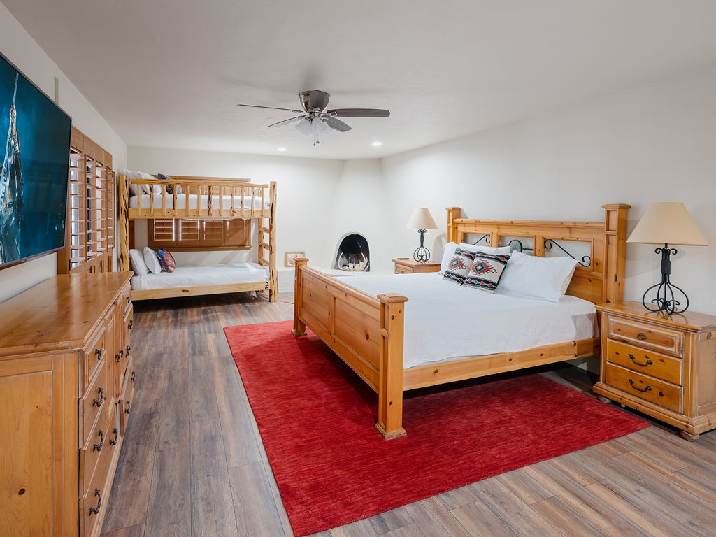 Primary bedroom with King bed, twin bunk beds, fireplace, smart tv, and en-suite bathroom