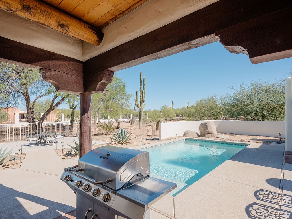 Large backyard with pool, bbq grill, fire-it, pingpong table, corn hole, and outdoor dining and seating area.