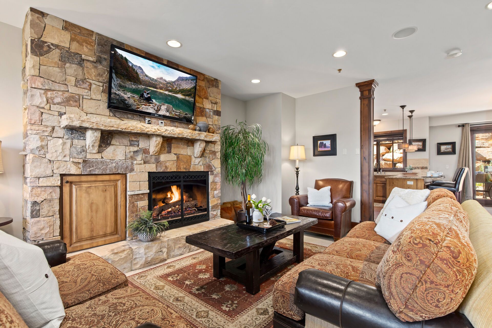 Living Room with gas fireplace, smart TV, plush furnishings including sofa sleeper, and private deck access