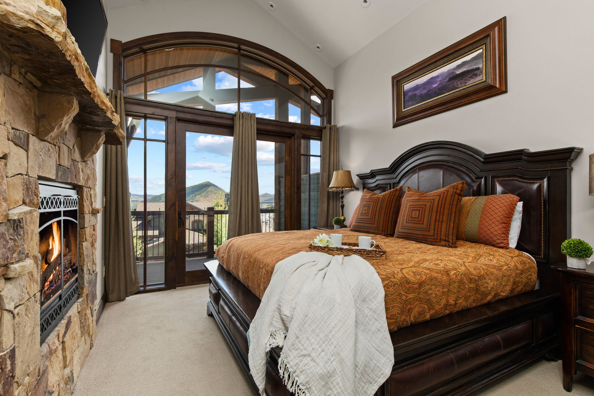 Master Bedroom with king bed, gas fireplace, smart TV, private balcony, and en suite bathroom