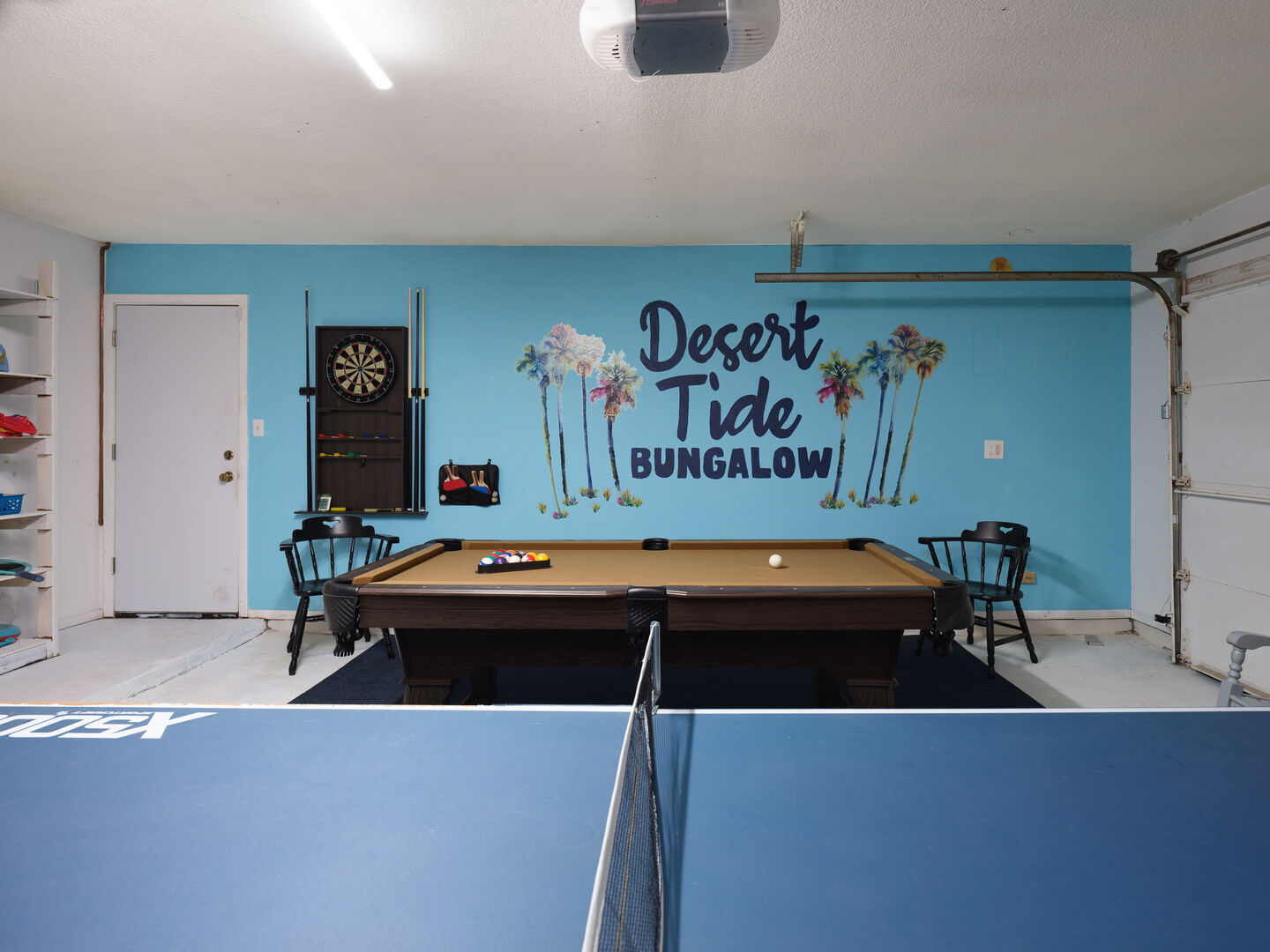Garage with pool table, ping pong table, and dart board.