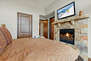 Master Bedroom with king bed, gas fireplace, smart TV, private balcony, and en suite bathroom