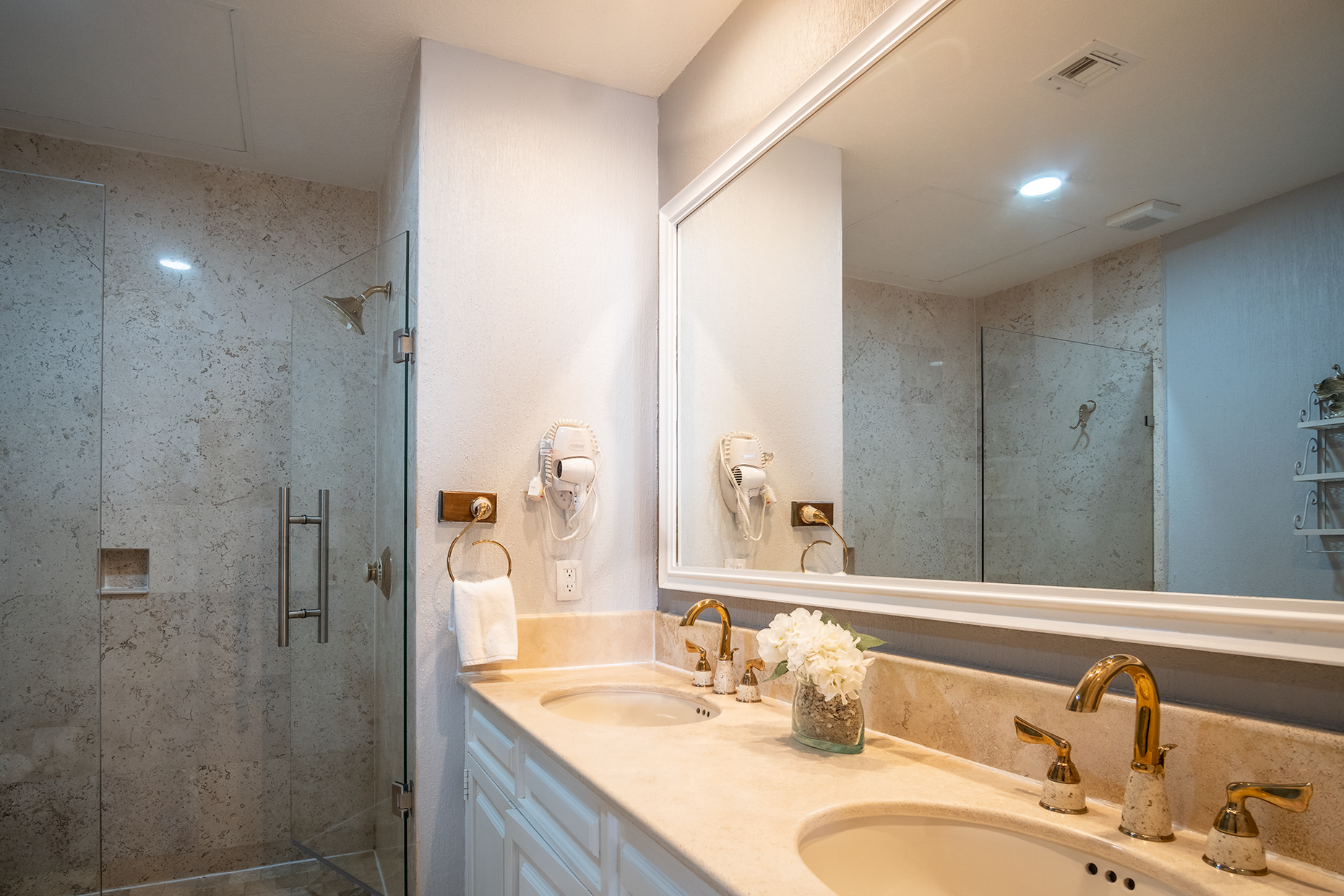 the main bathroom has a double sink vanity, and glass shower stall