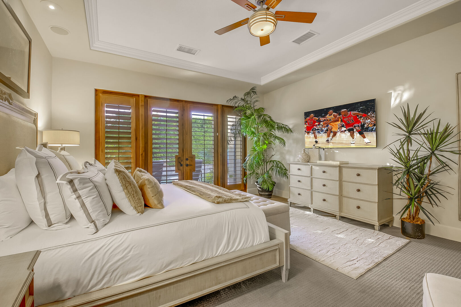 Master Suite 1 is located to the right of the hallway and features a King-sized Bed, 65-inch Samsung 4K Smart television, and remote-controlled ceiling fan.
