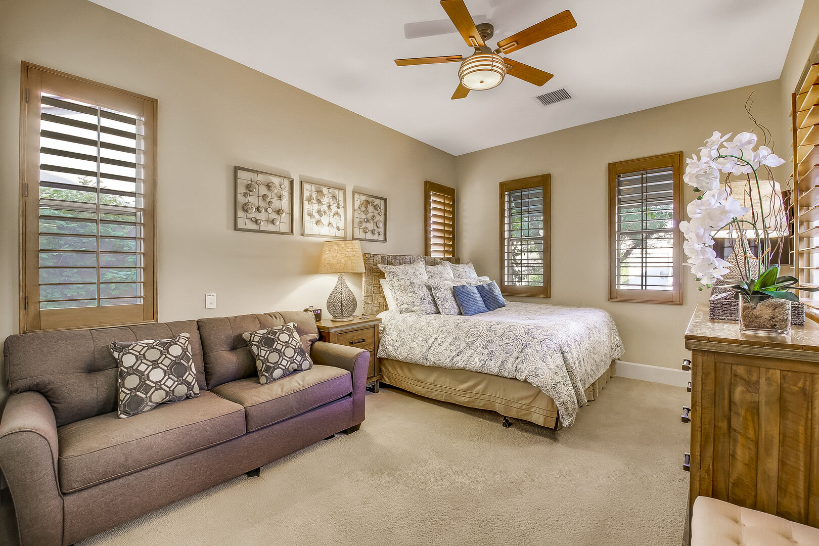 Suite 3 is next to the entrance doors and features a King-sized Bed, a Full-sized Sofa Sleeper, a 44-inch Samsung 4K Smart television, a remote-controlled ceiling fan, and a reach-in closet.