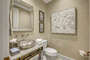 The powder room is across the master bedroom and features a decorative vanity sink.