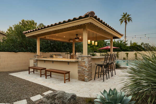 Expansive outdoor bar and kitchen featuring a BBQ Grill.