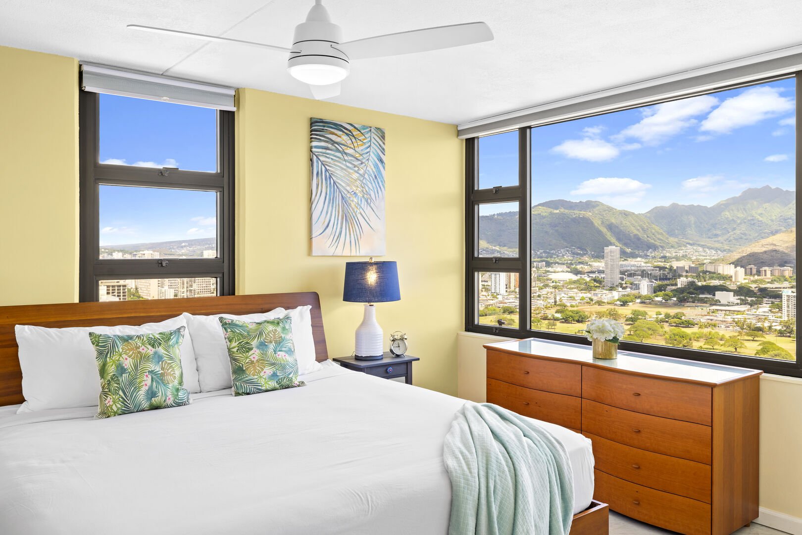 Bedroom with comfortable King-size bed,  ceiling fan, dresser and gorgeous mountain view