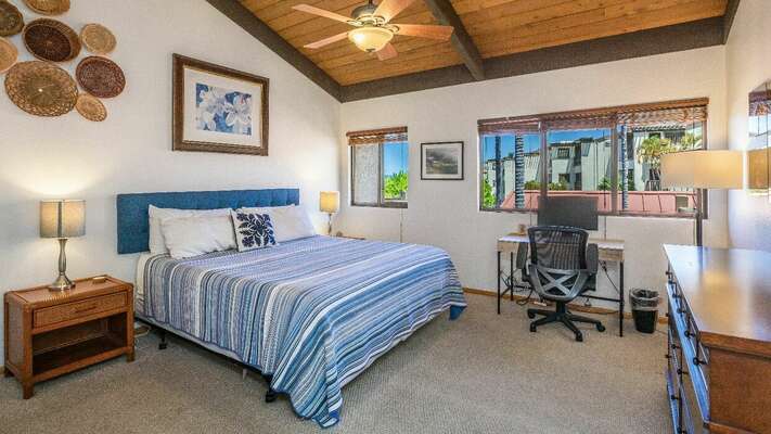 The bedroom is equipped with a Cal-king bed, a ceiling fan and workstation