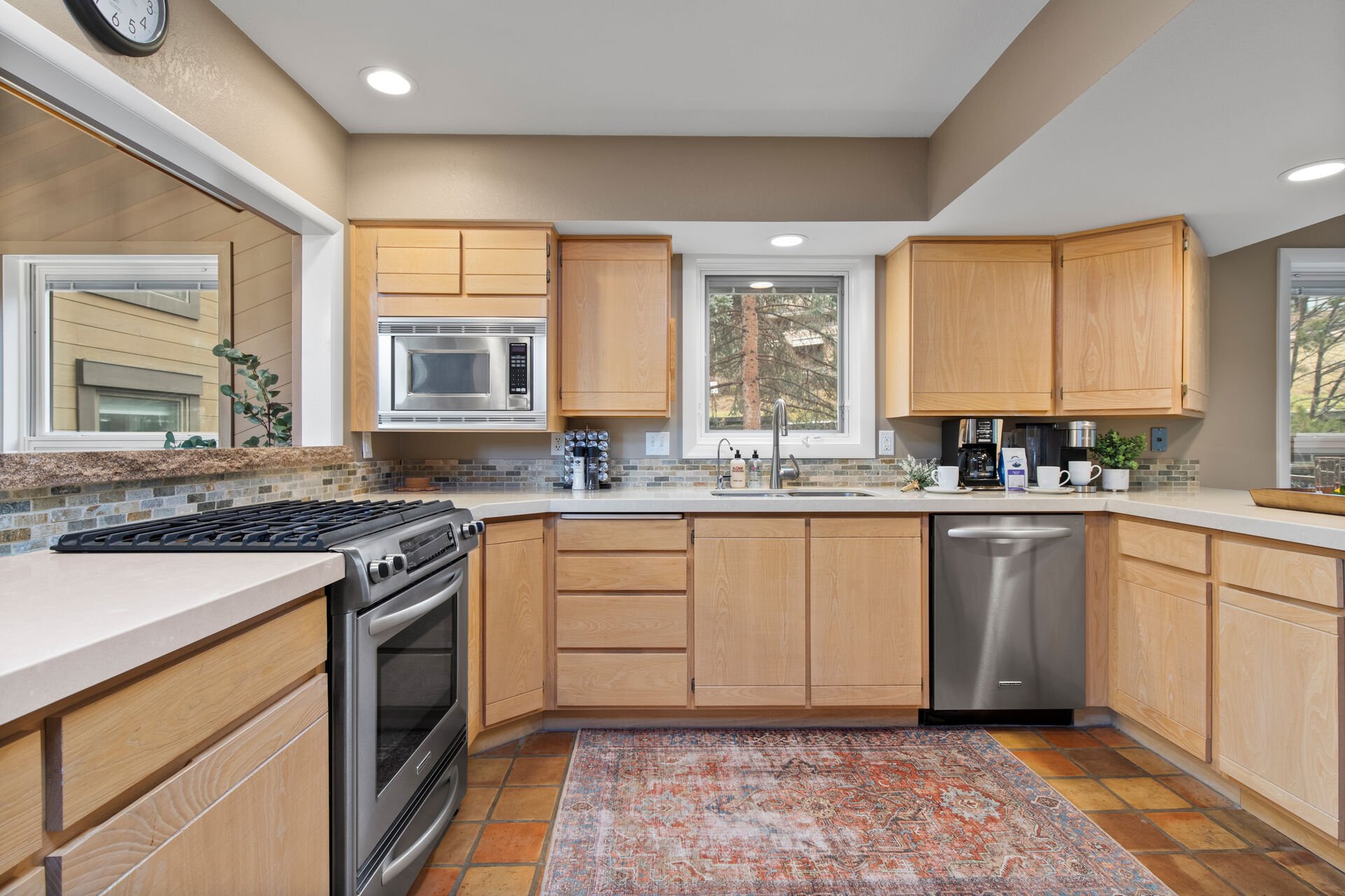 Fully equipped gourmet kitchen with stainless steel appliances,  stone countertops, separate breakfast nook/table area, bar seating for four, and access to the homes private back yard