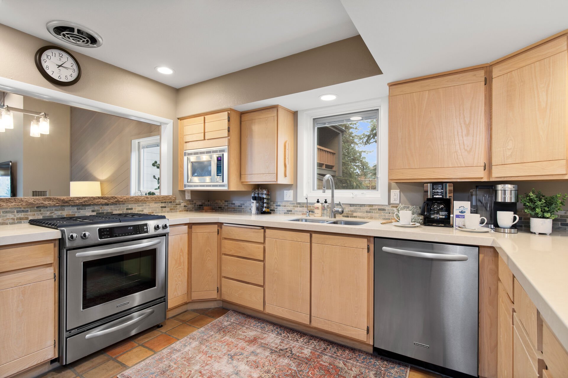Fully equipped gourmet kitchen with stainless steel appliances,  stone countertops, separate breakfast nook/table area, bar seating for four, and access to the homes private back yard