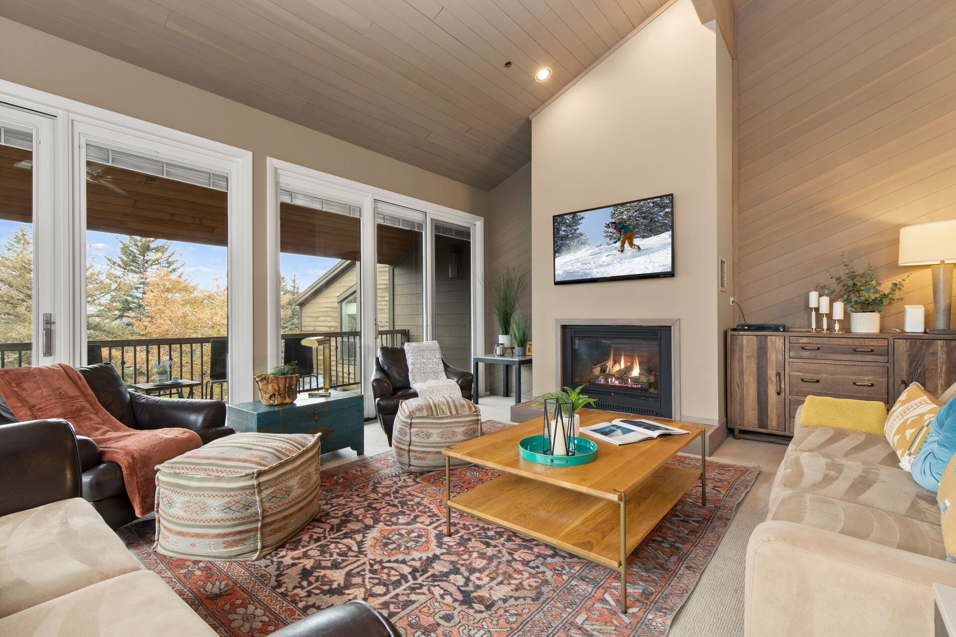 Smart TV, cozy gas fireplace, and patio access with views