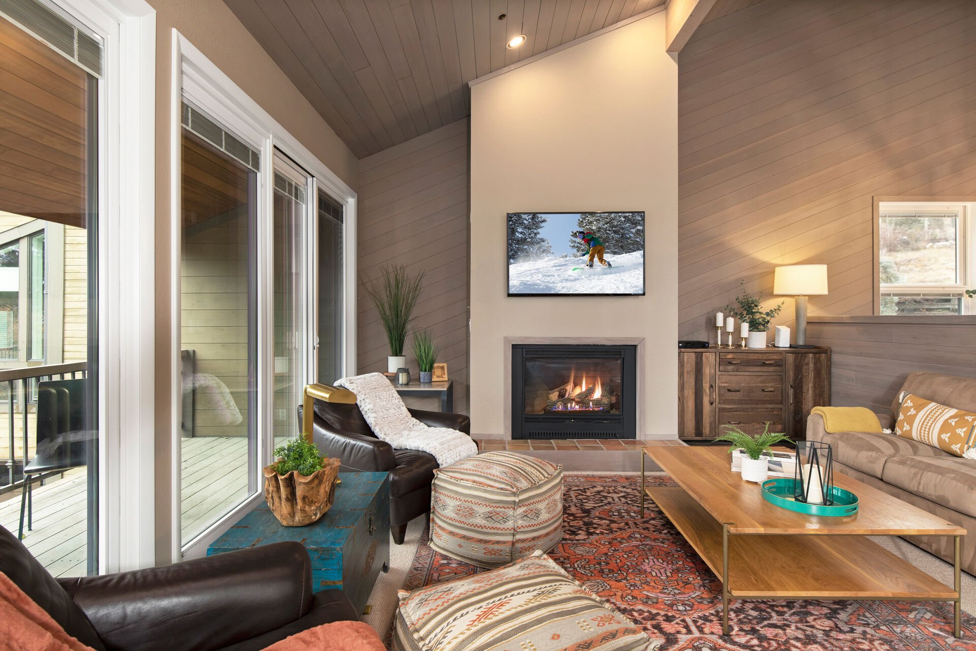 Smart TV, cozy gas fireplace, and patio access with views