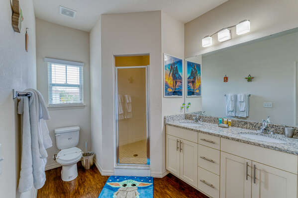 Upstairs shared bath with a dual sink vanity and shower.