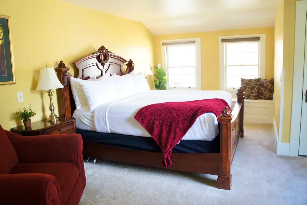 The Manitou Suite - A luxury two-room king suite featuring a dark burl wood king bed, with luxurious pillow top mattress, and hotel quality linens. French doors divide the 2 large rooms.