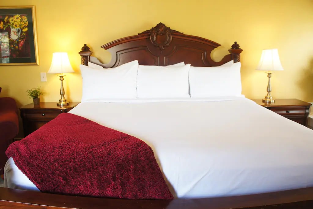 The Manitou Suite - A luxury two-room king suite featuring a dark burl wood king bed, with luxurious pillow top mattress, and hotel quality linens. French doors divide the 2 large rooms.