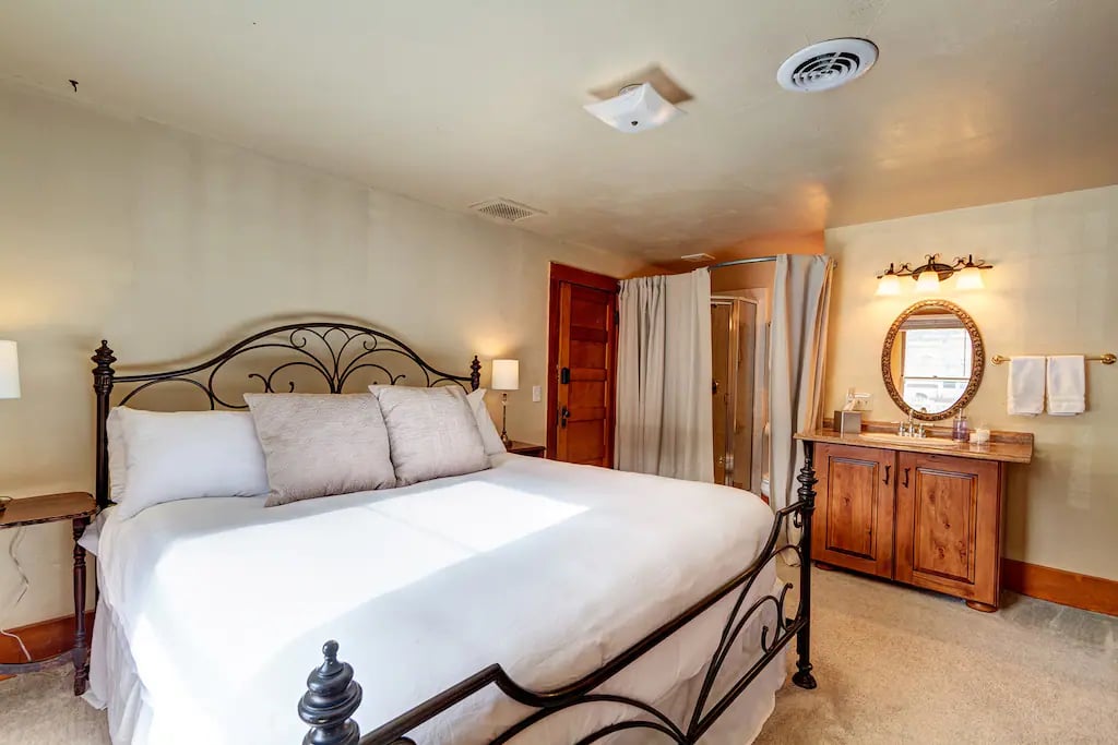 The Osage Room - A signature room at The Avenue.  Featuring a plush king-size bed with luxury linens and hotel quality pillows. Two oversized antique red velour chairs with an ottoman are tucked against the windows, a great place to kick up your feet
