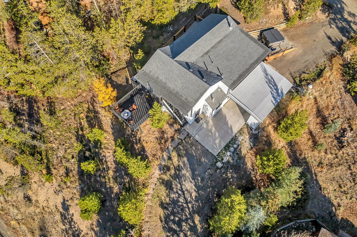 Arial overview of the home and layout, surrounded by trees and perched on a hill.
