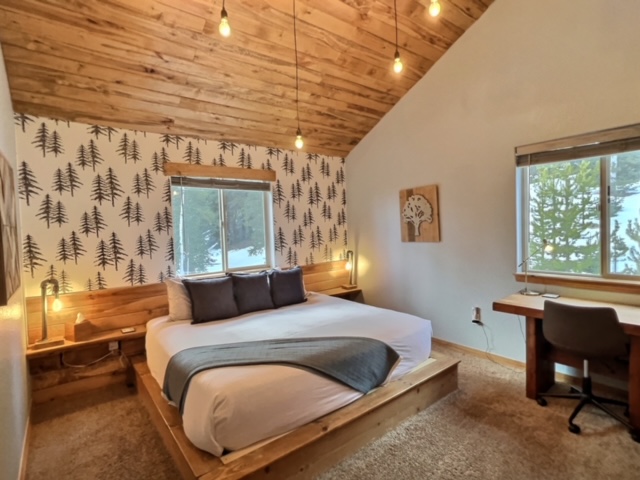 The Main Master Bedroom has a desk and office chair so you can catch up on emails while enjoying a picturesque view of the mountain and trees.