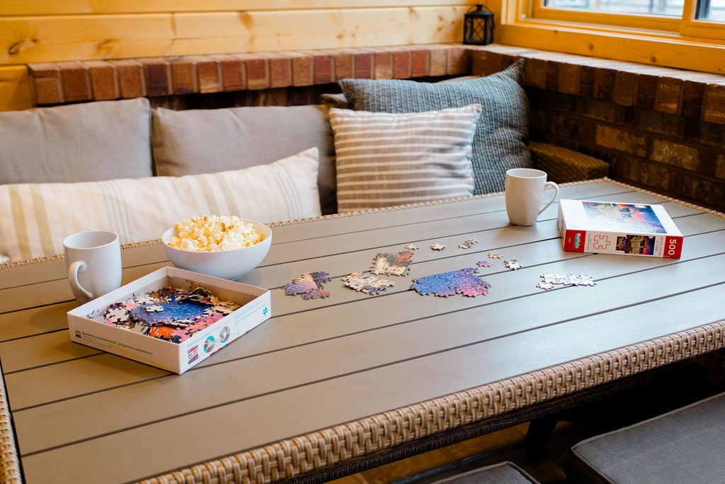 This space is ideal for family fun, featuring board games and a view of the outdoors where kids can be seen playing in the snow, building a snowman in the front yard. 