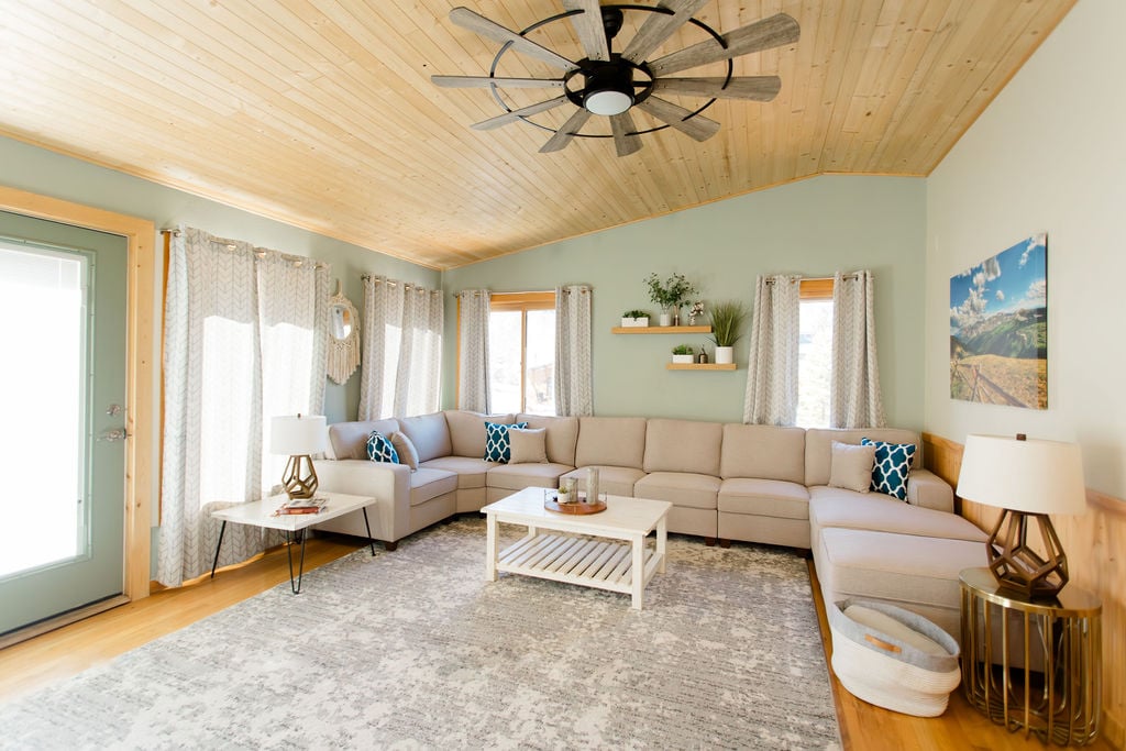 A welcoming living room awaits upstairs, complete with a plush sectional sofa, walk-out access to the top deck, and a Roku TV for entertainment. It's a cozy retreat for family gatherings or quiet evenings. 