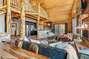 Marvel at the craftsmanship evident in the massive wood pillars, custom railings, and log walls and ceilings, enhancing the cabin's stunning aesthetics