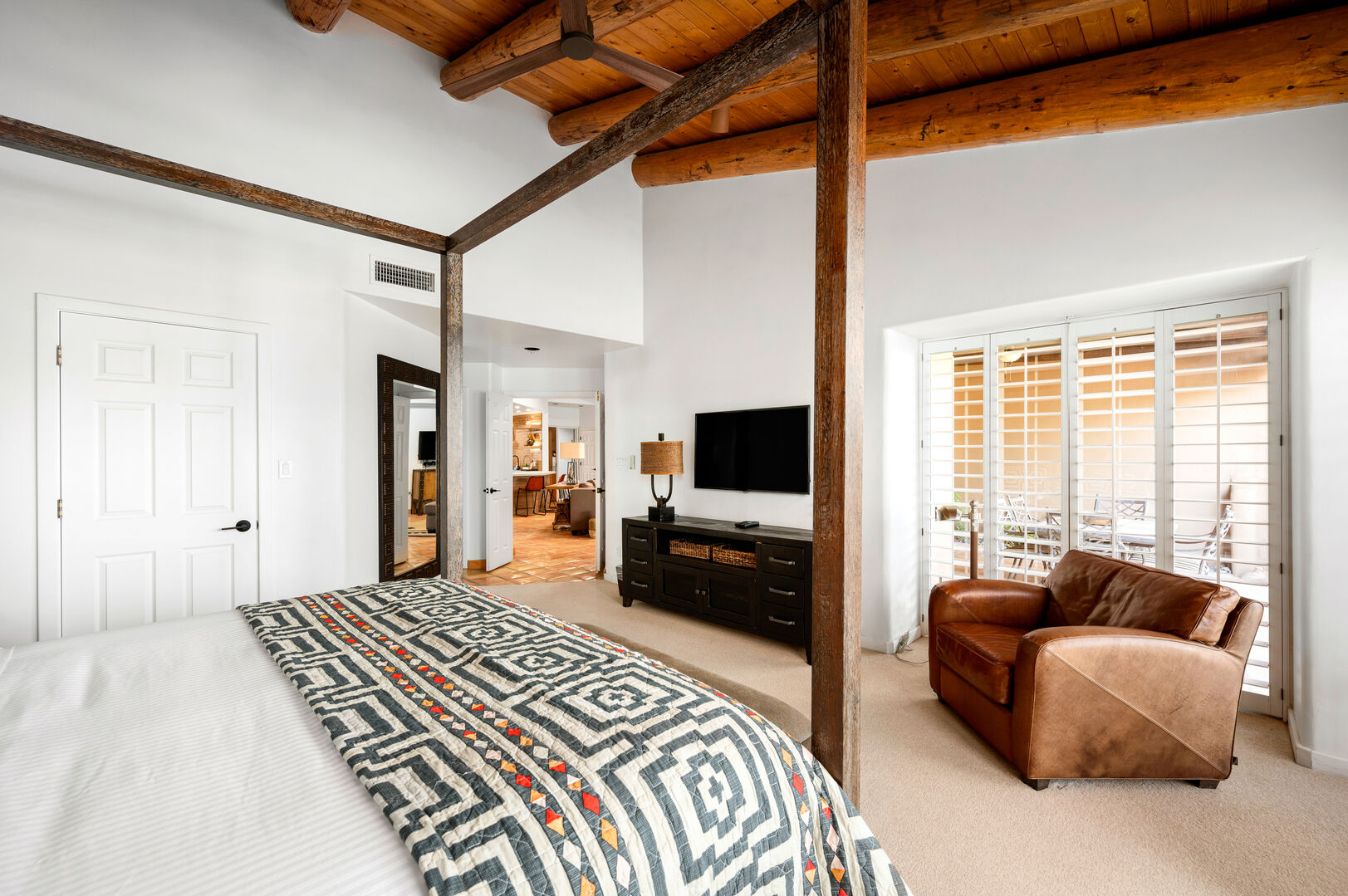 The master bedroom has a beautiful four-post bed and seating area.