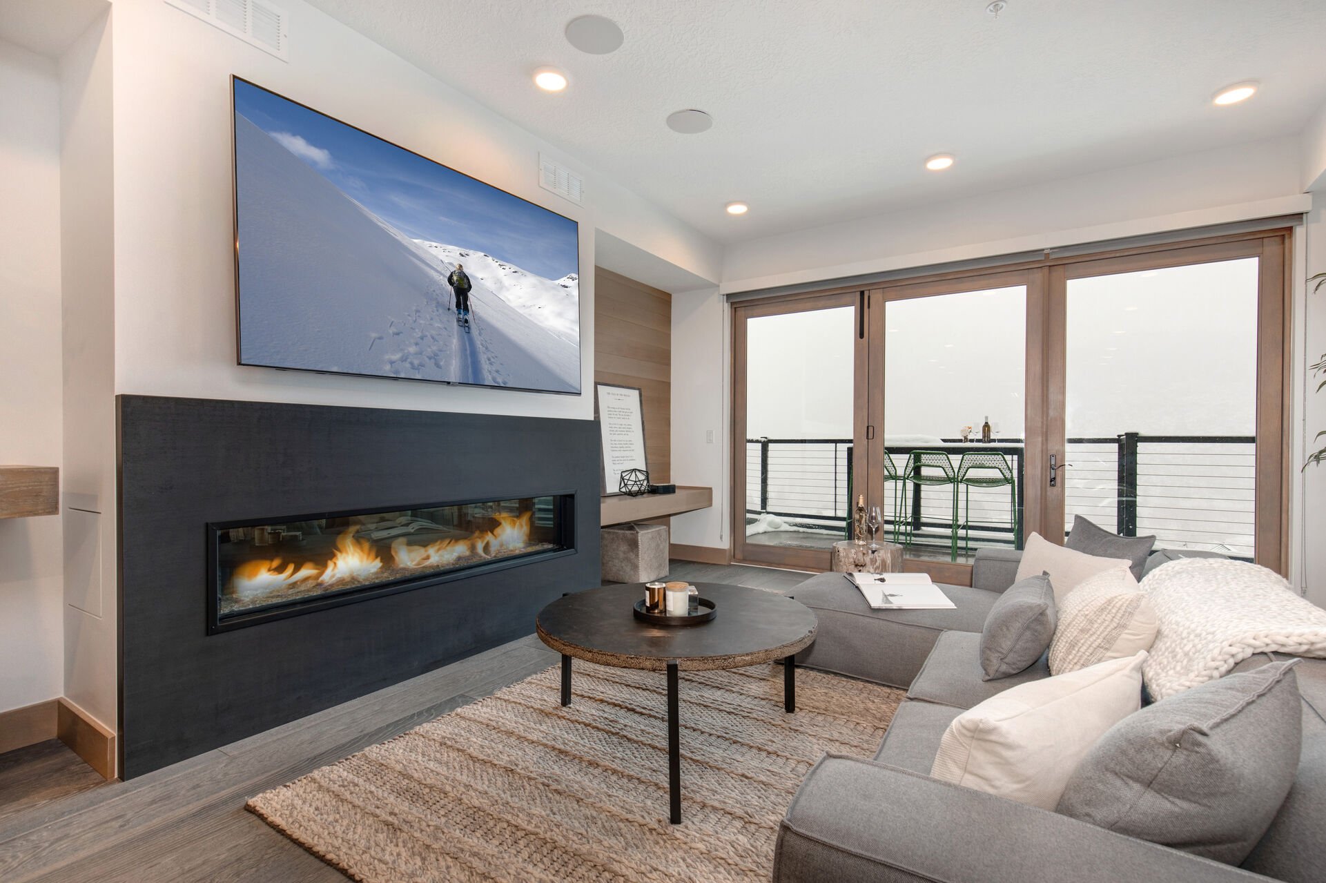 Living Room with sectional, Smart TV, gas fireplace, and private balcony access
