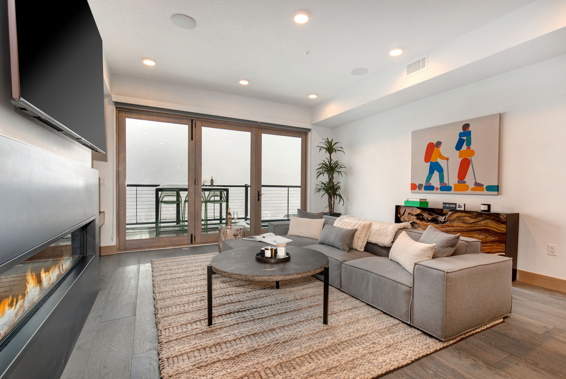 Living Room with sectional, Smart TV, gas fireplace, and private balcony access