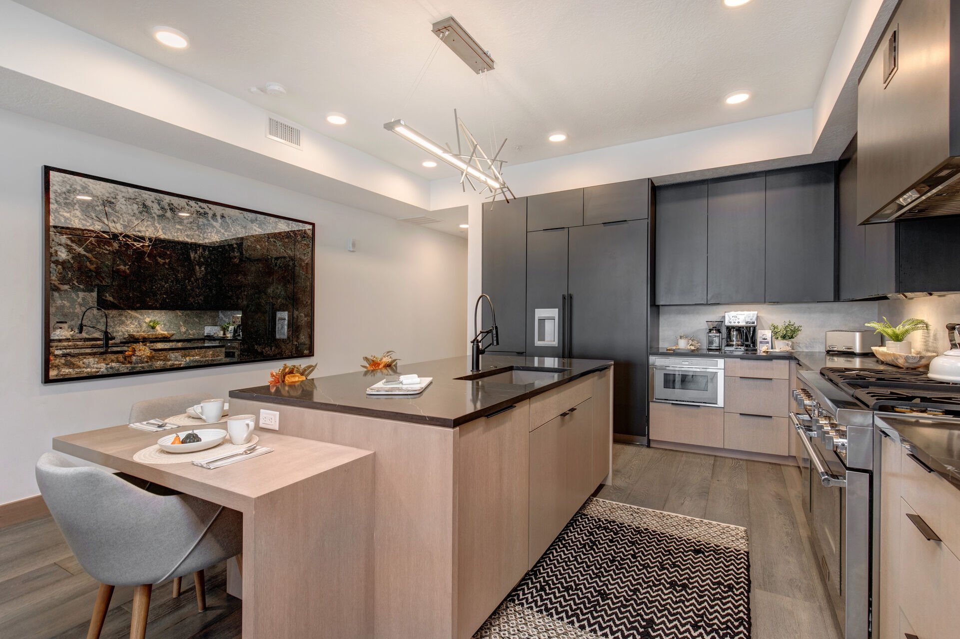 Fully Equipped Kitchen with high-end stainless steel appliances, a SubZero refrigerator with ice maker, gorgeous stone counter tops, and bar seating for four.