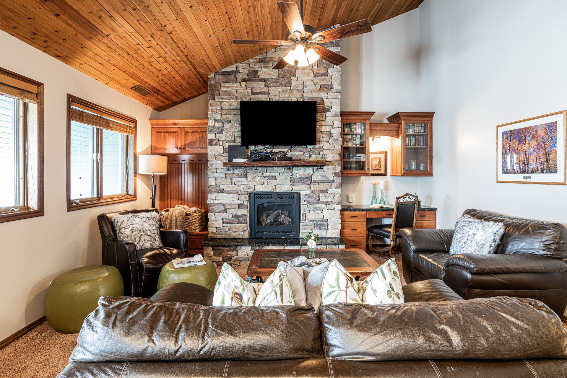 Living Room with leather couches, gas fireplace, smart TV & work desk