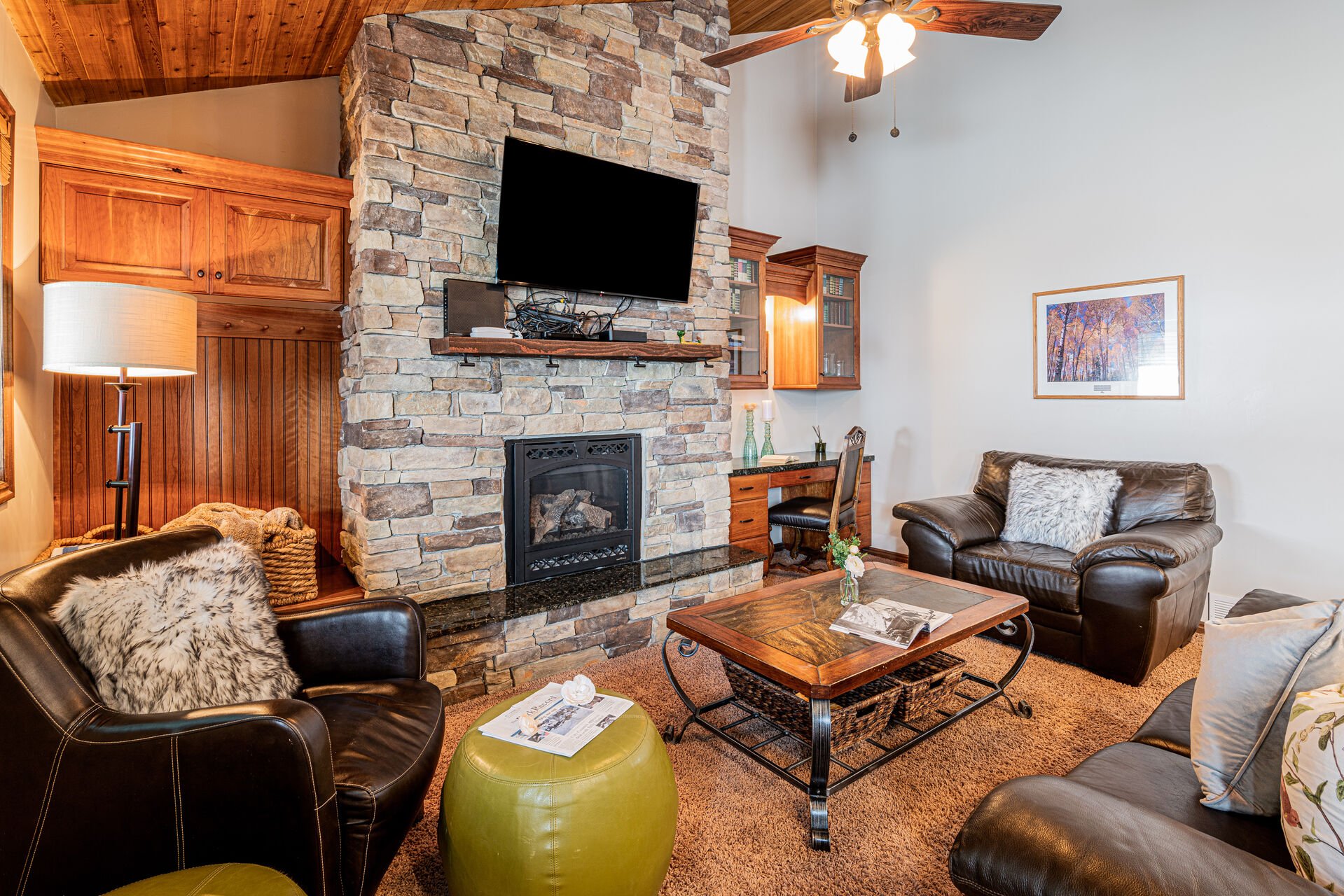 Living Room with leather couches, gas fireplace, smart TV & work desk