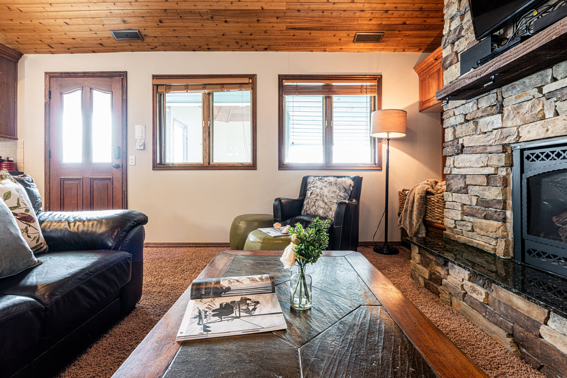 Living Room with leather couches, gas fireplace, smart TV & work desk