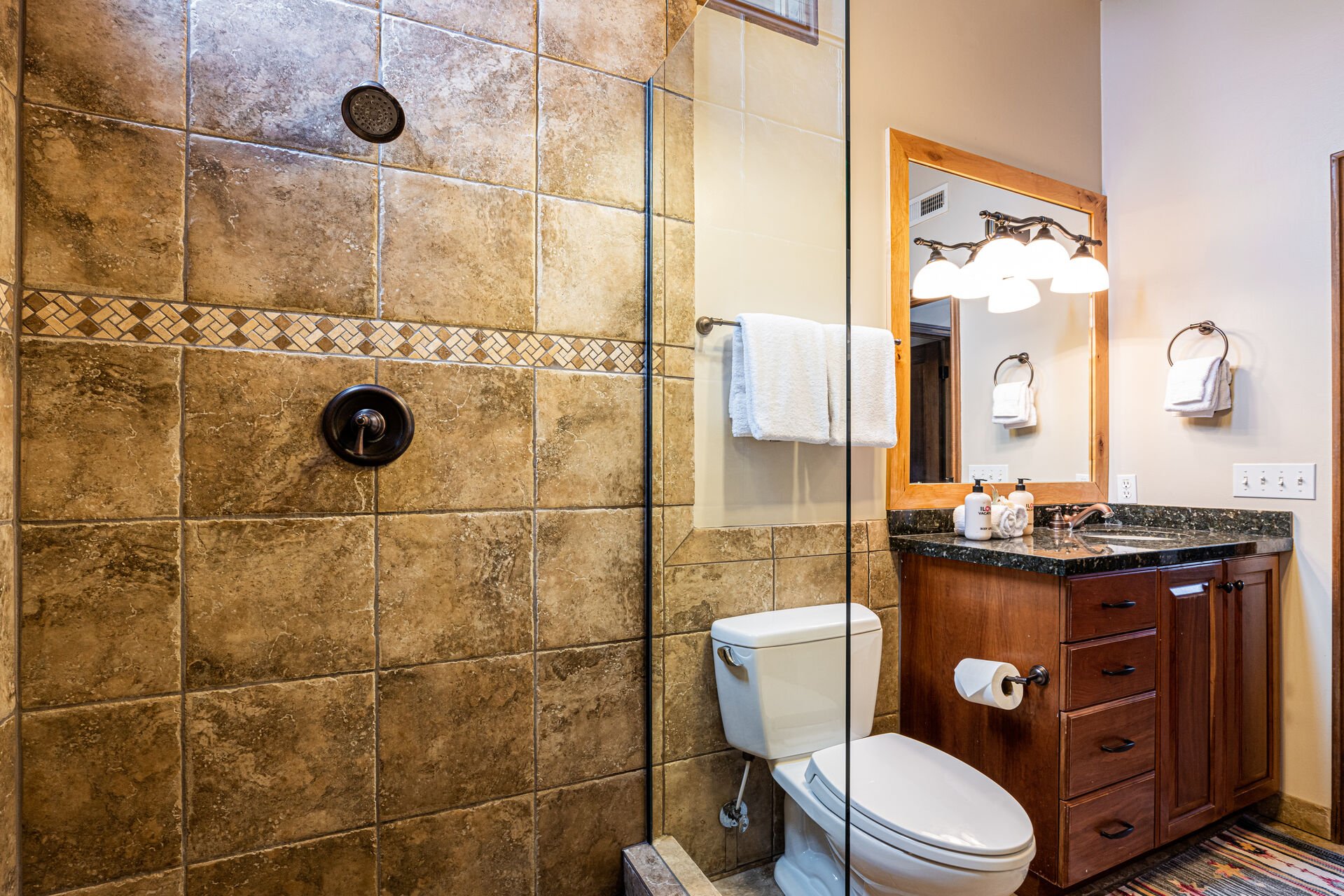 Shared Bathroom with glass & tile shower and washer/dryer units