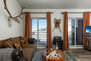 Living Room/Sleeping Space with plush sofa, queen bed (with twin rollaway), work desk, 32