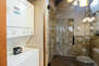 Shared Bathroom with glass & tile shower and washer/dryer units