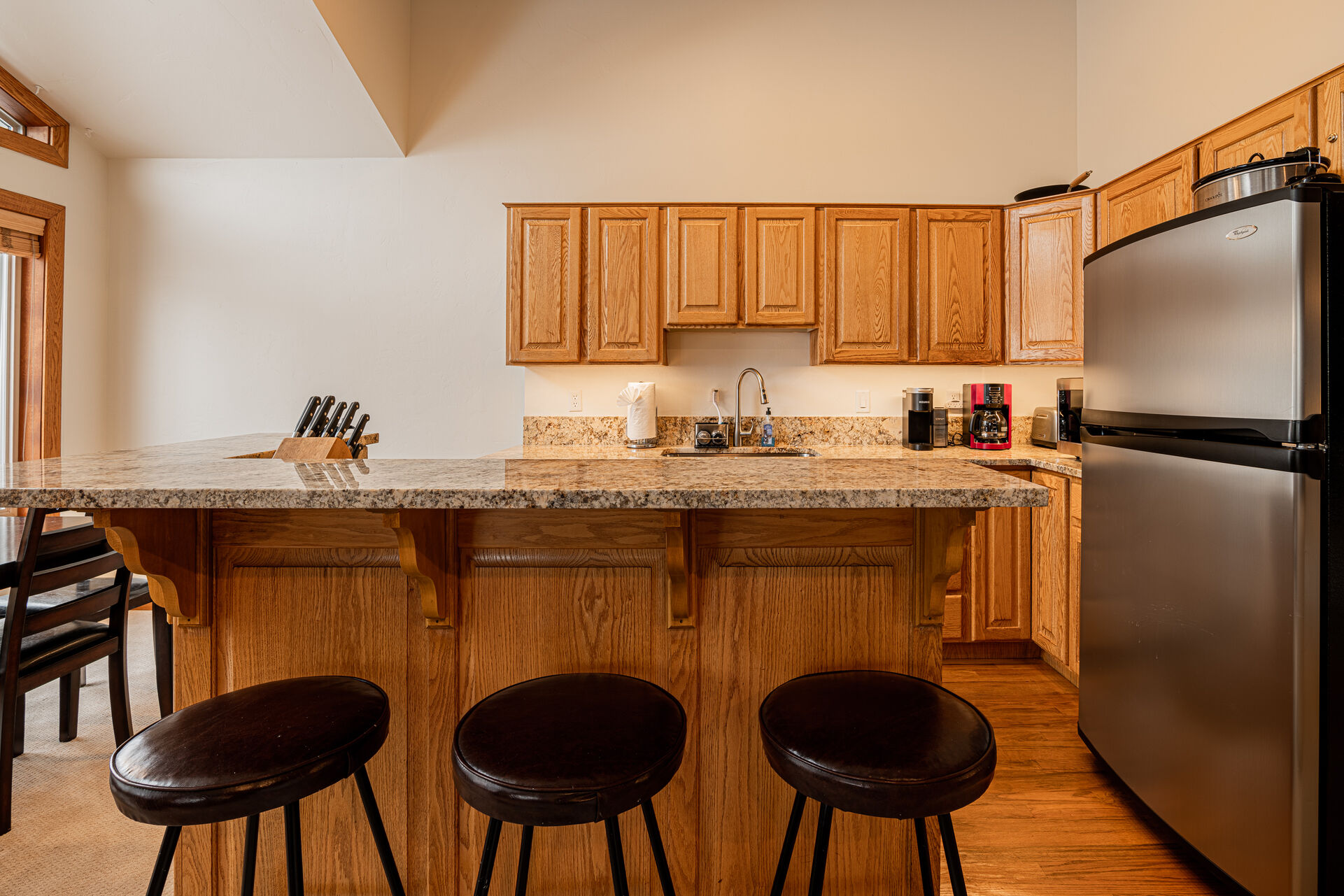 Fully Equipped Kitchen with stone countertops, stainless steel appliances, and bar seating for 3