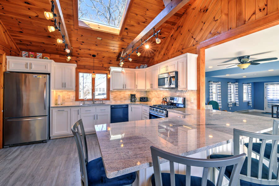 Beautiful updated kitchen with granite countertops, island that seats 6 guests and a wooden accent ceiling.