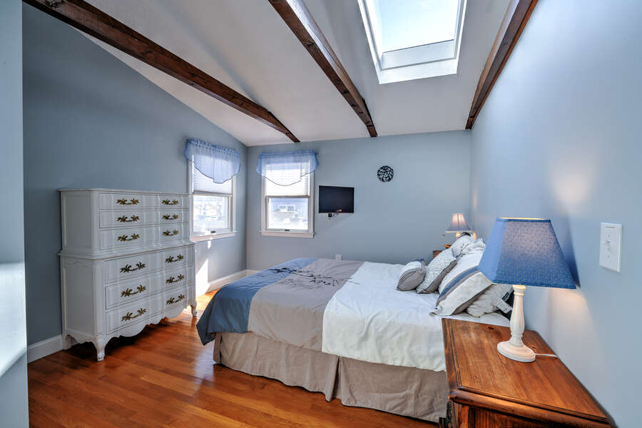 Bedroom #1 with storage and natural light through the skylight.
