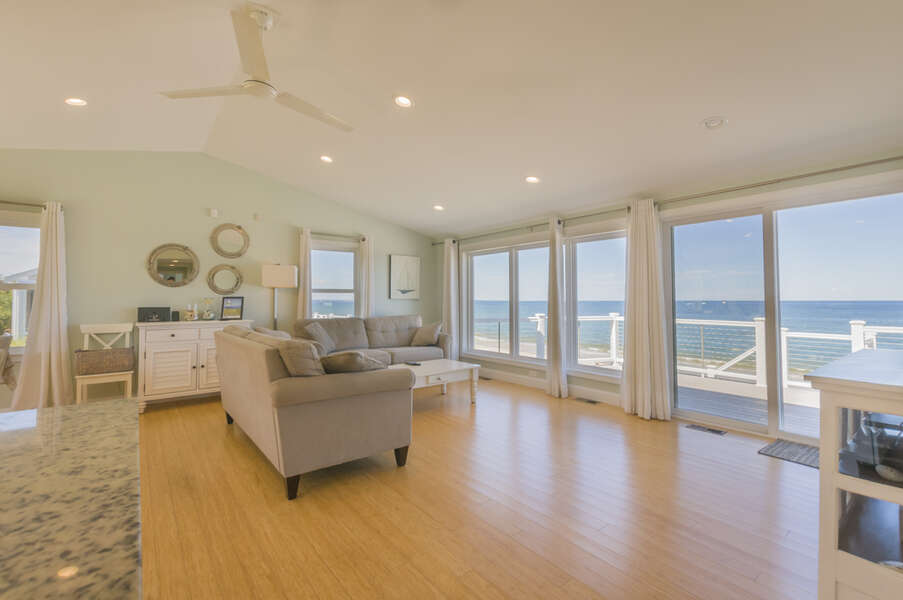 Living room that allows for sunlight with the view of the ocean.
